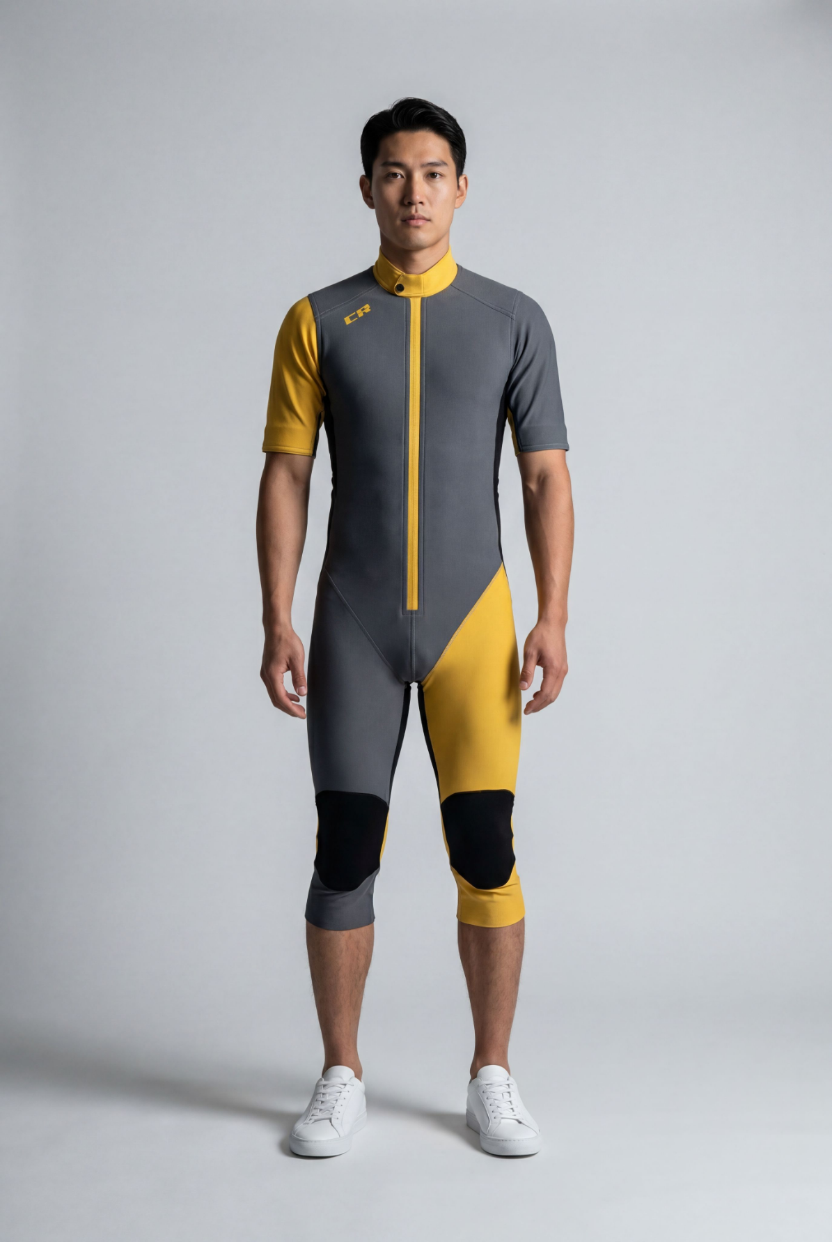 Person wearing a gray and yellow cycling suit on a plain background