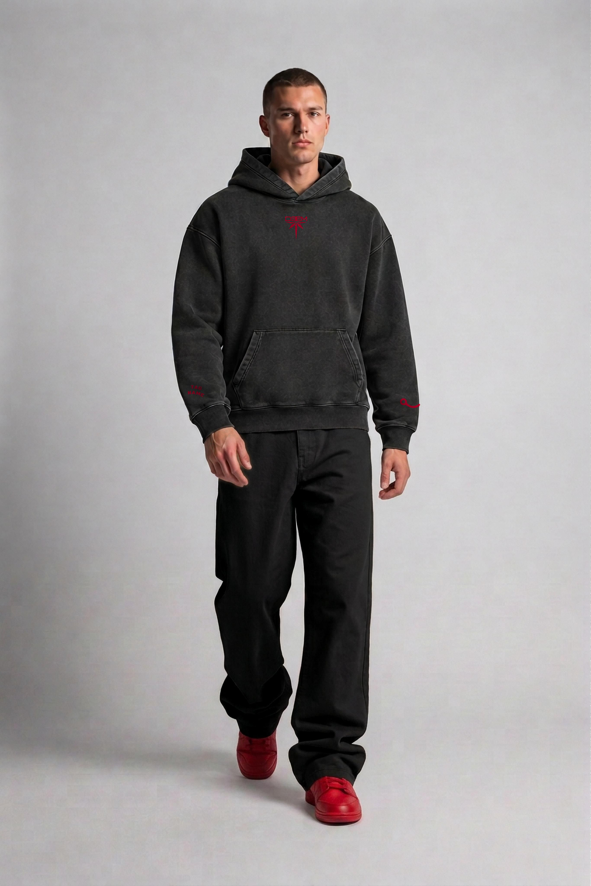 Model wearing the Bandana Vintage Hoodie in garment-dyed black, front view with red DEEM sygnet on the chest